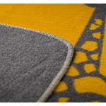 Close-up of a yellow and gray textured blanker with a geometric pattern.